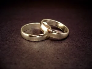 Two simple, silver wedding bands rest on a dark surface, one ring slightly overlapping the other—symbolizing unity and new beginnings, much like the journey guided by Dallas citizenship and naturalization lawyers.