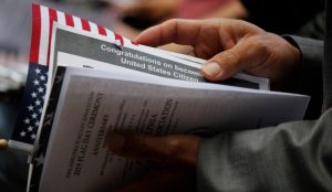 Person holding permanent citizenship documents after working with Katy Citizenship Lawyer.