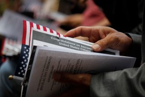 A person holds papers, including one that reads “Congratulations on becoming a United States Citizen,” at a ceremony—an achievement often guided by a knowledgeable Houston citizenship attorney.